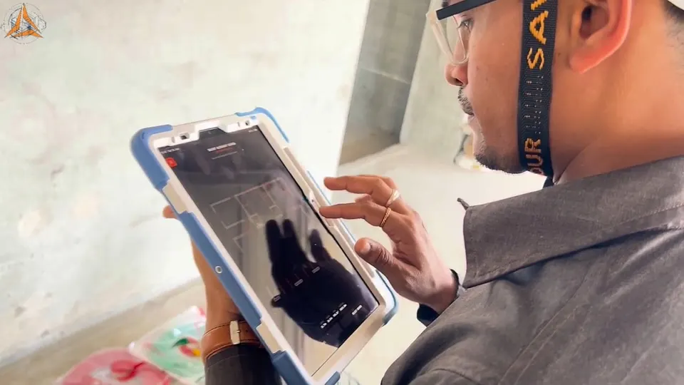 A site engineer holding an iPad with the BIM model over the room